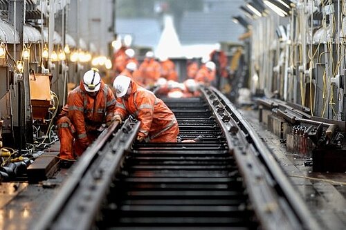 Men performing works on train tracks.